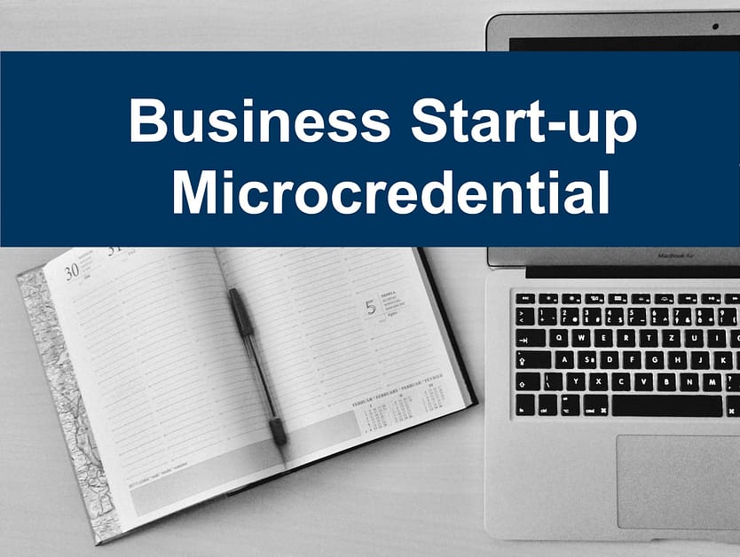 Business Start-up Microcredential text on a background with a scheduler and laptop.